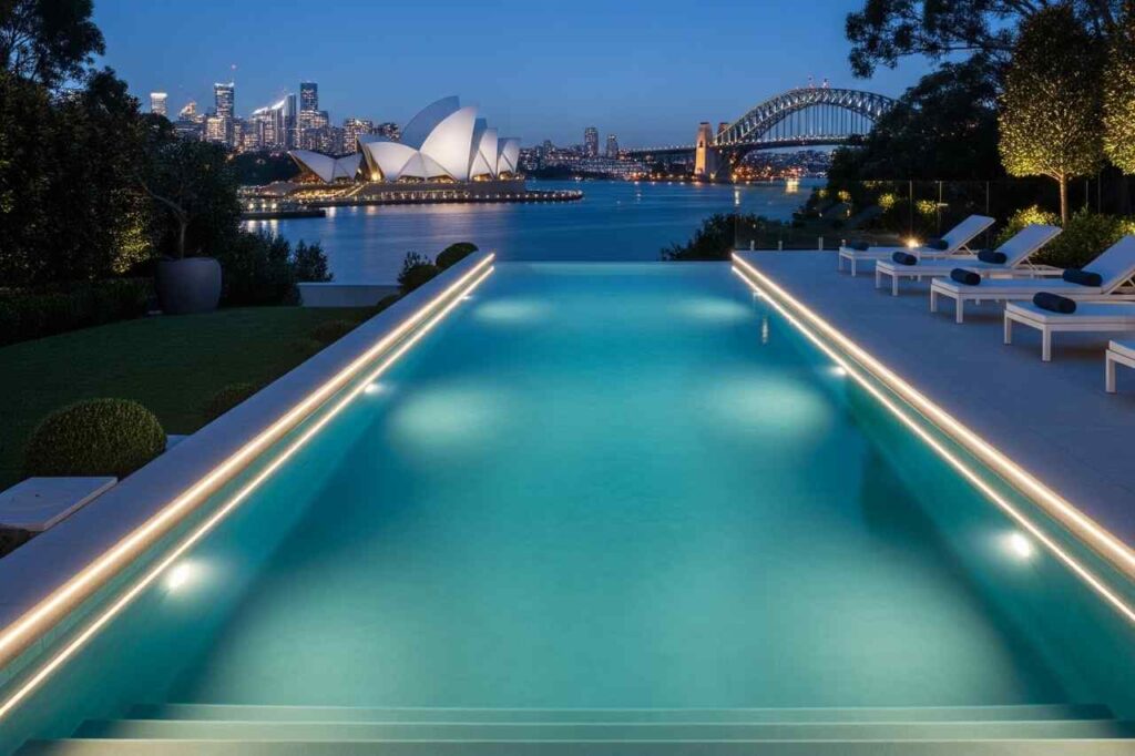 Infinity edge pool in Sydney with LED lighting, overlooking the Opera House and Harbour Bridge at night.